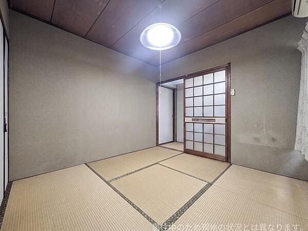 畳の落ち着いた色合いが印象的な和室です。引き戸と障子の組み合わせが和の雰囲気を際立たせています。天井や照明もシンプルで空間に調和しています。収納スペースも確保されています。