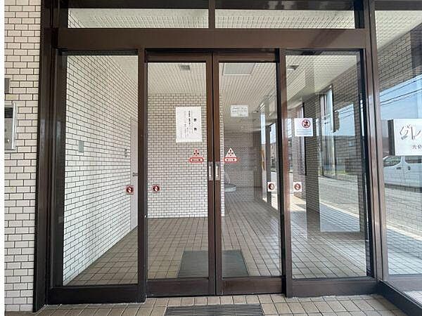 エントランスはガラス扉で開放感のある雰囲気です。明るいタイル貼りの内装が清潔感を感じさせます。道路からのアクセスもスムーズです。共用部分がよく手入れされている印象です。