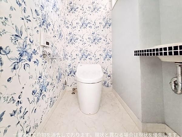 爽やかな花柄の壁紙が印象的なトイレです。床は明るいカラーでお手入れもしやすそうです。ワイドな空間設計がゆとりを感じさせます。シンプルな中にもこだわりを感じる一室です。