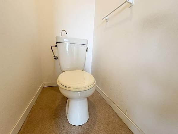 シンプルなデザインで清潔感のあるトイレです。壁際にはタオル掛けが設置されています。掃除がしやすい床も特徴的です。空間を有効活用した配置となっています。ゆったりとしたスペースでご利用いただけます。