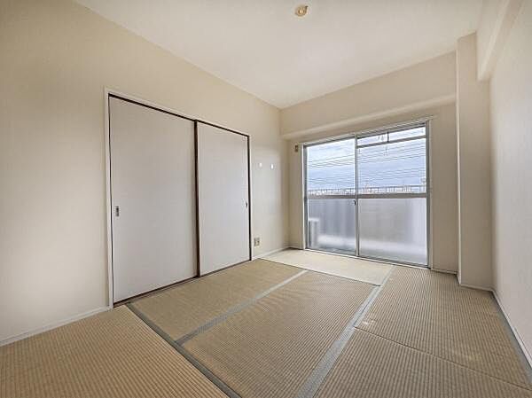 明るい日差しが差し込む和室です。シンプルな内装で落ち着いた雰囲気を感じられます。収納スペースも備わっておりすっきりとした空間が広がります。畳の質感が柔らかな印象を与えます。