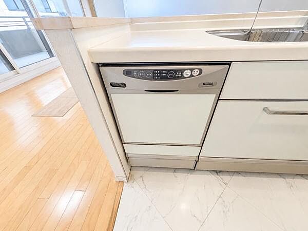キッチンにはビルトインタイプの食器洗浄乾燥機が設置されています。シンプルなデザインで収納スペースも豊富です。作業動線が確保されており普段使いにも適しています。