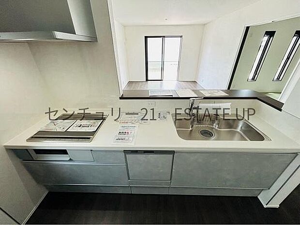 【キッチン】リビング全体を見渡せる対面式キッチン。リビングで過ごすご家族を見守りながら作業ができ、お互いの顔を見ながら会話ができます。上部に吊り戸棚がなく、開放的です。