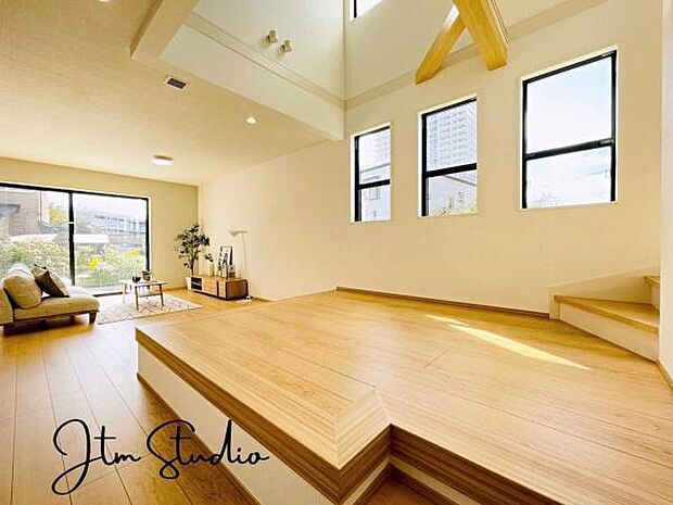 段差を活かした小上がりのフリースペースは、家族のくつろぎやお子様の遊び場、ワークスペースとしても活躍。吹抜けの高天井と大きな窓から光が差し込み、開放感あふれる心地よいリビング空間を演出してくれます◎