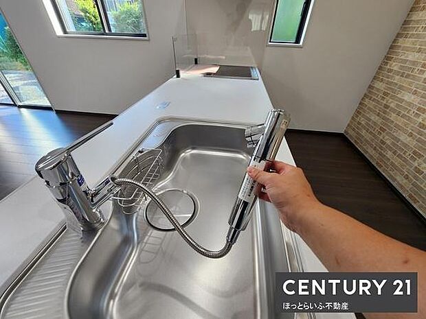 広々としたキッチンは明るい窓から光が差し込み清潔感ある空間です。シンクには便利なシャワー水栓が備え付けられています。作業スペースが確保されており調理も快適です。収納スペースも充実しています。