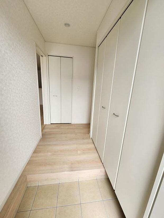 玄関はシンプルなデザインで清潔感があります。収納スペースが備わっておりすっきりとした印象です。明るい色調の床材が空間を広く感じさせます。段差が少なく使いやすさにも配慮されています。