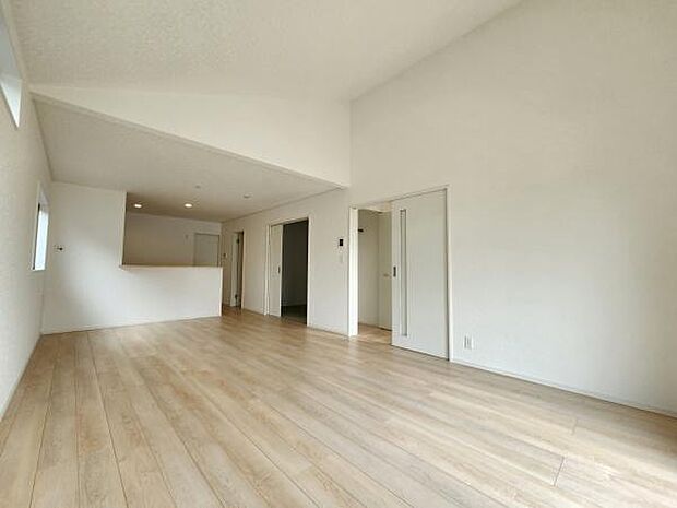 リビングは明るい色合いのフローリングで室内が広々とした印象です。天井が高く開放感が感じられます。大きな窓から自然光が差し込むので日中も快適な空間です。