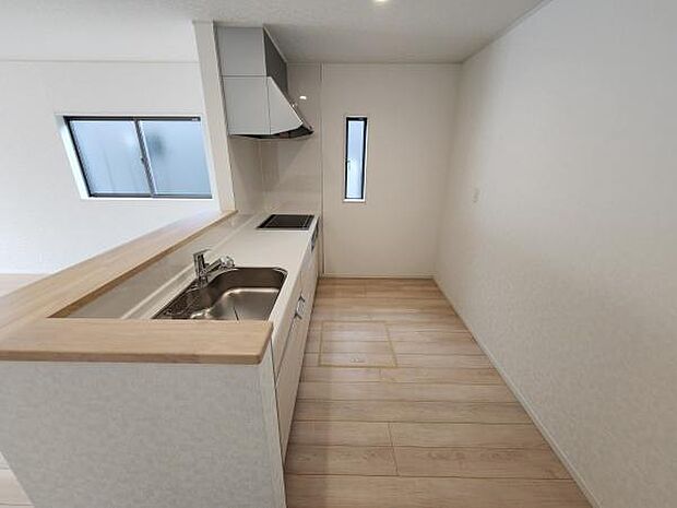 リビングに隣接したキッチンは開放感があります。明るい雰囲気で使いやすい空間です。窓からの自然光が差し込み清潔感が感じられます。ナチュラルなフローリングが全体をすっきりとまとめています。