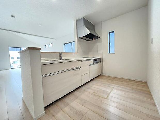 リビングとキッチンがひと続きの開放的な空間です。明るい光が差し込み窓の配置が工夫されています。シンプルで清潔感のある内装が特徴です。床材と壁の色合いが調和しておりすっきりした印象です。