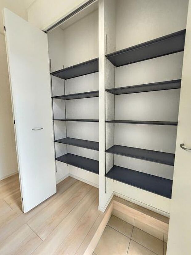 シンプルなデザインの収納スペースが備わっています。棚は高さが異なり整理整頓がしやすい仕様です。奥行きも十分に確保されているので様々な用途に対応可能です。扉付きのため見た目もすっきりと保てます。