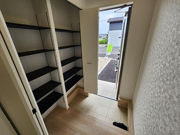 玄関横に設置された収納スペースは奥行きと高さのある棚で多用途に活用できます。扉付きなので中身をすっきり隠せます。玄関付近の配置で使い勝手の良さが感じられます。