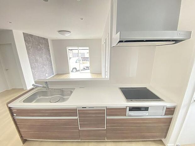 シンプルで使いやすいキッチンです。木目調デザインが空間に調和しています。IHクッキングヒーターとシンクが一体型で日々のお手入れがしやすい仕様です。収納も豊富で整理整頓がしやすいキッチンです。