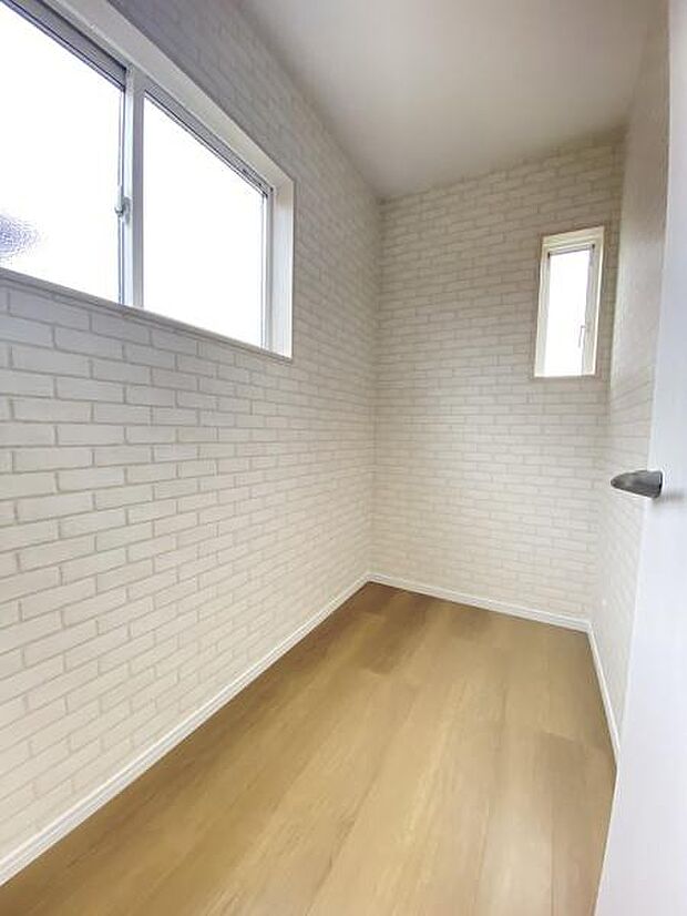 明るい陽射しが差し込む収納スペースです。ホワイトのレンガ調クロスが空間に清潔感を与えています。換気に便利な窓付きで湿気対策もしやすいです。奥行きがありさまざまな収納ニーズに対応しやすい仕様です。
