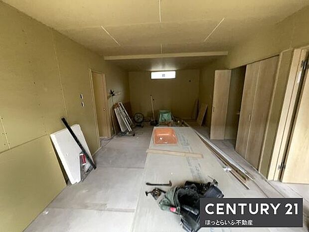 前面道路が広く車両の出入りがしやすい環境です。周囲には住宅が並び落ち着いた雰囲気が感じられます。舗装された道路が整然としており歩行にも安心感があります。青空の下で開放感のある現地写真です。