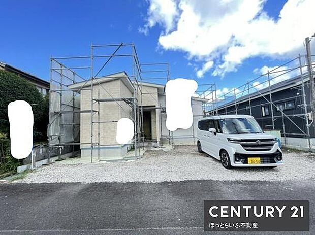 シンプルな外観が特徴の新築住宅です。駐車スペースも広く車の出し入れがしやすい設計です。青空と白い外壁のコントラストが印象的です。建築中の状態がよくわかります。