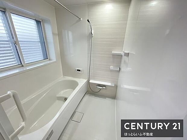 清潔感のある明るいバスルームです。浴槽とシャワースペースがしっかり分かれています。窓付きで換気もしやすい設計です。手すりが付いているのも便利です。