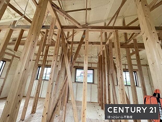 木の温もりを感じる建築途中の現場写真です。柱や梁がしっかりと組まれています。採光も考えられた設計で開放感が感じられます。現地の様子がよく伝わる一枚です。