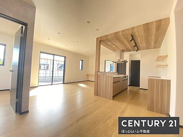 大きな窓から自然光がたっぷり入り明るく開放的なリビングです。木目調の床と天井で温かみを感じられます。キッチンとの繋がりが良く使い勝手にも配慮した設計です。