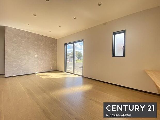 広々とした空間が印象的なリビングです。大きな窓からは自然光がたっぷり差し込みます。明るい床材が開放感を演出しています。シンプルで使いやすいレイアウトも魅力です。