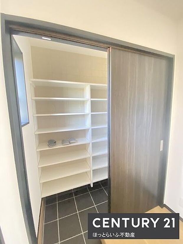 可動式の棚が設置されており多様なアイテムを整理しやすい収納空間です。明るさが保たれており室内のアクセスもスムーズです。スライドドアが設けられているためスペースを有効に活用できます。