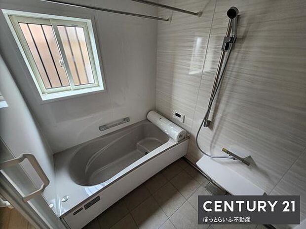 明るい窓から自然光が差し込むバスルームです。浴槽とシャワースペースが分かれていて使いやすいです。お手入れしやすい壁材と床材が採用されています。換気用の窓もあり湿気対策にも役立ちます。