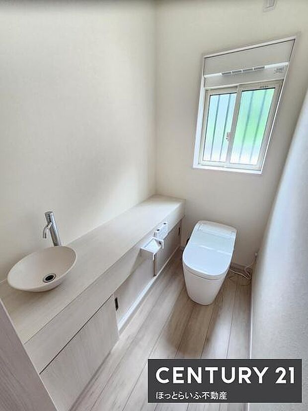 明るい光が差し込むトイレ空間です。清潔感のある白を基調とした内装が特徴です。収納スペースもありすっきりとした印象を持てます。窓があり通気性にも配慮されています。