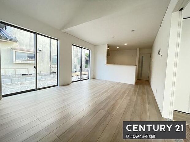 大きな窓から明るい日差しが差し込むリビングです。ナチュラルなフローリングが空間を広く見せています。開放感が感じられる間取りです。キッチンとのつながりも良好です。