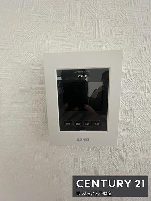 壁面に設置されたモニター付きインターホンで室内から来客を確認できます。操作ボタンがシンプルで使いやすい配置です。セキュリティ面の安心感をサポートします。設置場所もすっきりとしています。