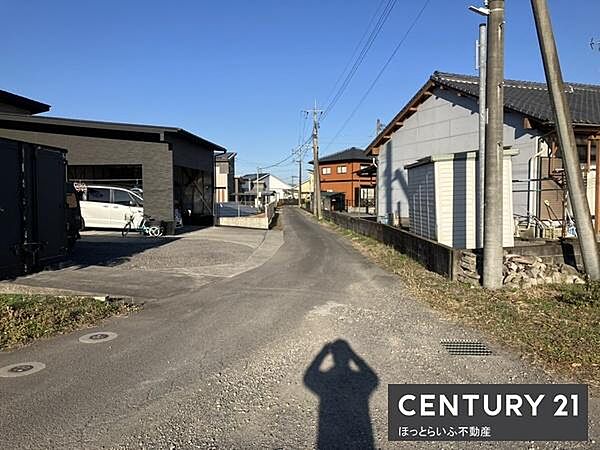 現地前面道路は舗装されており周辺は住宅が立ち並ぶ静かな環境です。道路幅も確保されているため車両の通行がしやすい印象です。電柱や配線も整然としており生活利便性も感じられます。周囲の景観も開放的です。