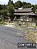 外観：緑に囲まれた現地土地写真です。敷地は広々としており開放感があります。建物の陰影が落ち着いた雰囲気を感じさせます。周囲には自然が多く静かな環境です。南側からの撮影で日当たりの様子もわかります。