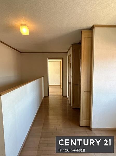 落ち着きのある木目調のフローリングと建具が印象的な室内です。廊下はゆったりとした幅で移動しやすい造りです。シンプルな壁面が空間を広く感じさせます。収納スペースも確保されていて便利です。