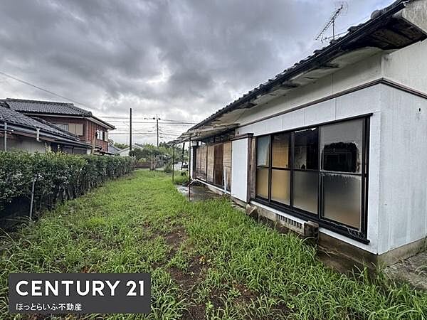 広い敷地を活かした現地土地写真です。建物の周囲には開放的なスペースが広がっています。周辺は落ち着いた住宅街になっています。建物の窓からは自然の光を取り入れることができます。敷地の緑が印象的です。