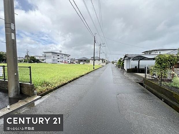 前面道路が広く車の通行にも便利です。周囲は落ち着いた雰囲気の住宅街です。空が広く感じられ開放感があります。道路脇には緑も豊かでゆったりとした印象です。