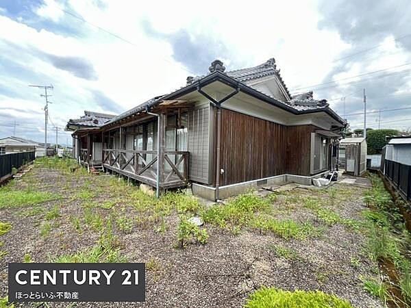 和風の外観が特徴的な一戸建てです。広々とした庭があり周囲に開放感があります。ウッドデッキ風の縁側が建物に趣きを添えています。落ち着いた雰囲気の木造住宅です。