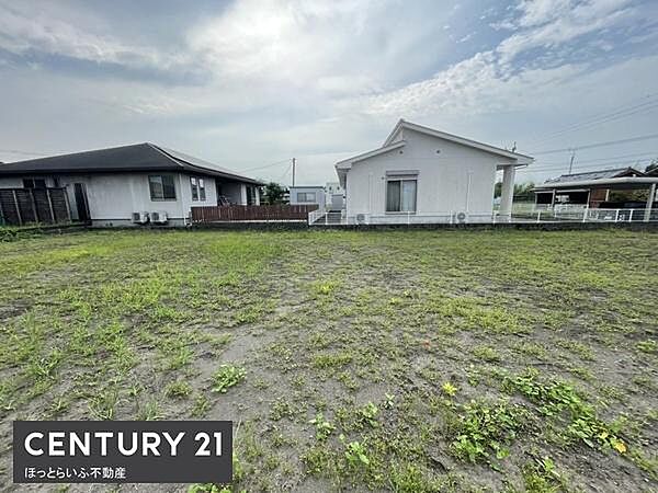 開放感のある現地土地写真です。周囲には住宅が並び落ち着いた雰囲気が広がります。敷地は整った形状が魅力となっています。静かな住環境が感じられる一枚です。空まで視界が広がる眺望もポイントです。
