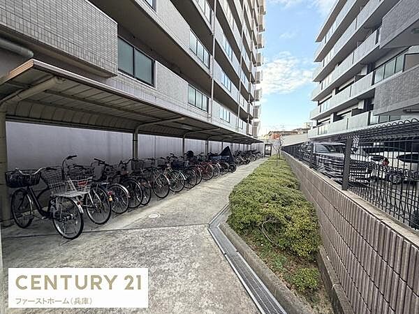 マンション敷地内に屋根付きの自転車置き場が設置されています。自転車が複数台停められる広さがあります。建物がしっかりと管理されている印象です。周囲がきれいに整備されています。