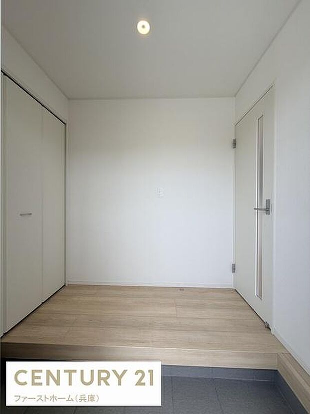 シンプルなデザインが印象的な玄関です。白を基調とした空間が広がりを感じさせます。フローリングとタイルの切り替えもスタイリッシュです。収納スペースもしっかり設けられています。