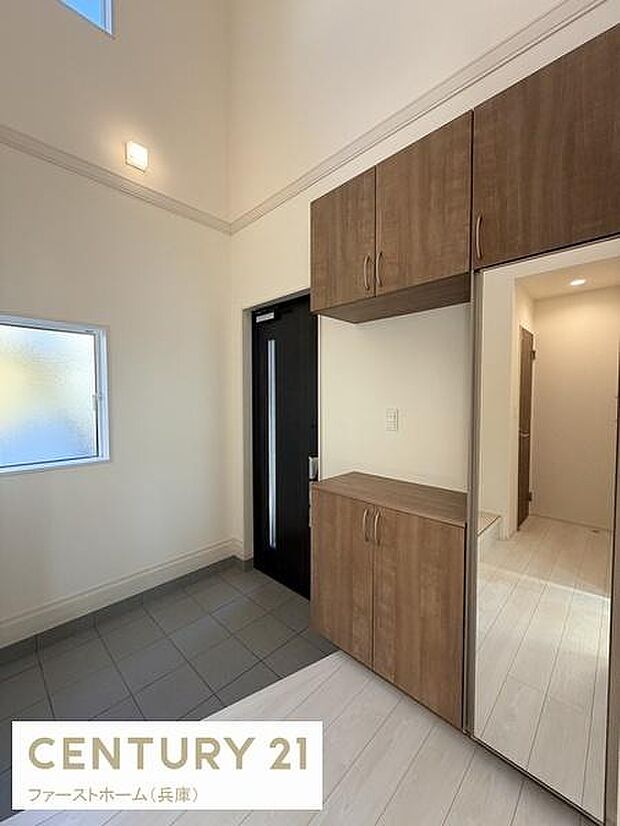 玄関スペースが広く上部に窓があるため採光も確保されています。シューズボックスが備え付けられており収納力も期待できます。タイルとフローリングの切り替えにより空間がすっきりと仕上がっています。