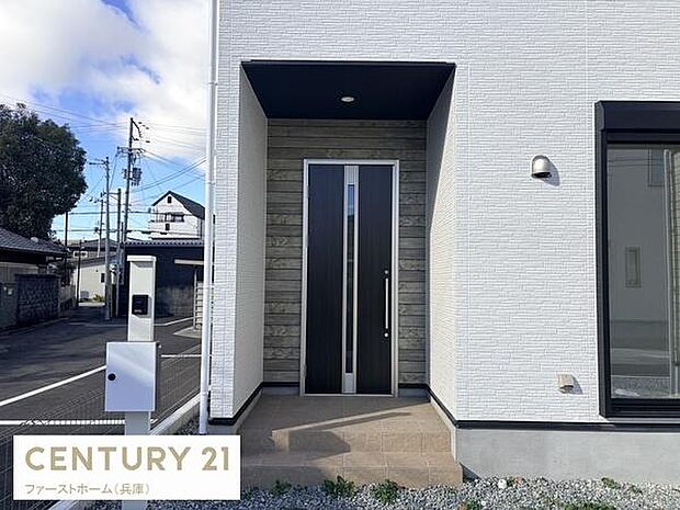 シンプルなデザインの玄関が落ち着いた雰囲気を演出しています。ドア周りの木目調が外観のアクセントになっています。独立したポストも設置され機能性にも配慮されています。