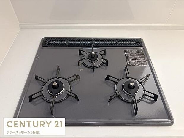 3口コンロが設置されており調理スペースとしても十分に活用できます。グリルや操作パネルも視認しやすい配置です。キッチン全体が清潔感のある印象を与えます。お手入れもしやすいコンロ周りです。