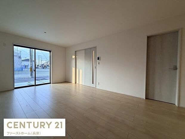 大きな窓からたっぷりと光が差し込むリビングです。シンプルな内装が落ち着いた雰囲気を演出しています。すっきりとしたフローリングで自由なレイアウトが可能です。開放感のある空間が広がっています。