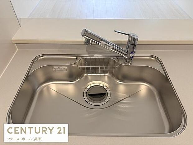 シンプルで清潔感のあるキッチンシンクが印象的です。広々とした設計で日々のお手入れもスムーズに行えます。蛇口も使いやすいデザインです。開放的なカウンターキッチンが特徴です。