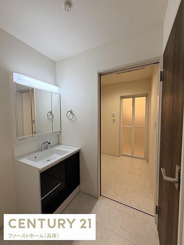 すっきりとした印象の洗面台が設置されています。収納スペースが確保されており日常使いに便利です。ミラーキャビネット付きで使い勝手も考慮されています。明るい照明が清潔感を引き立てています。