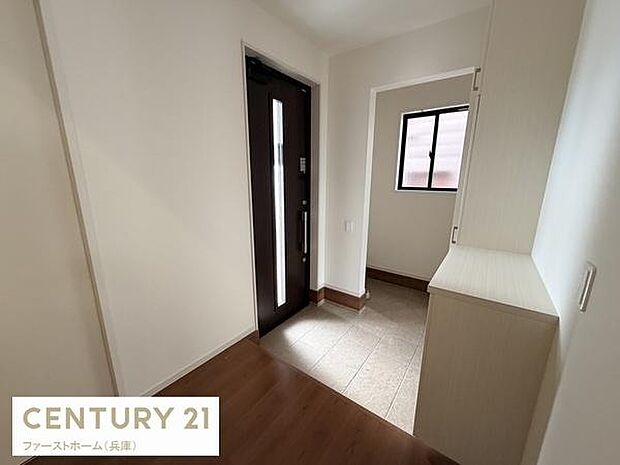 玄関は明るい色合いで統一され清潔感があります。収納スペースが設置されており使い勝手を感じられます。窓から自然光が入りやすい設計です。出入りの動線もスムーズな印象です。