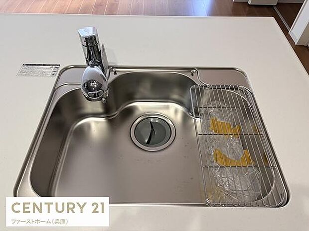 ステンレスシンクが清潔感を演出しています。広々とした作業スペースが確保されておりシンプルなデザインが特徴的です。水栓や排水口まわりもスッキリとまとまっています。