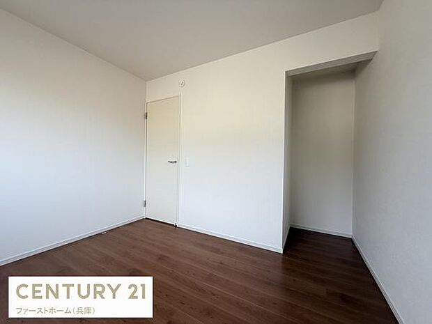 シンプルな内装で落ち着いた雰囲気の洋室です。白い壁とダークなフローリングが清潔感を引き立てています。使いやすい形状なので多様なレイアウトが可能です。収納スペースも備わっています。