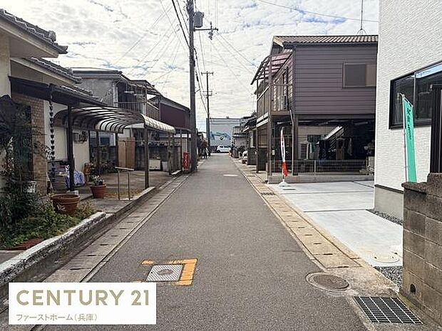 周辺は落ち着いた雰囲気が広がる前面道路です。車通りが少なく安心して過ごせる環境が整っています。家の前の道路もきれいに整備され歩きやすさが感じられます。電柱や街灯もあり夜間も安心して通行できます。