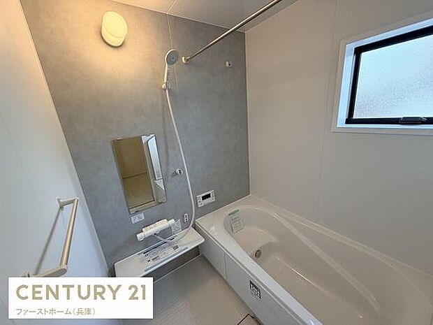 清潔感のあるバスルームです。ゆったりとした浴槽が備わっています。窓があり換気もしやすい設計です。手すりが設置されており使いやすさにも配慮されています。