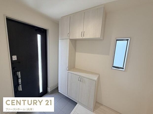 玄関スペースは明るく清潔感のある内装です。シューズボックスが備え付けられており収納も充実しています。小窓があることで採光も確保されています。落ち着いた色味が空間を引き締めています。