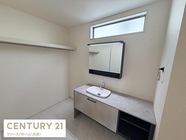 シンプルなデザインの洗面スペースです。窓からの自然光がしっかり入り明るい雰囲気です。収納スペースも備えており利便性が感じられます。鏡も大きめで使い勝手が良い印象です。清潔感のある内装が特徴的です。